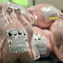 Packaged farm-raised poultry with a label on a dark surface